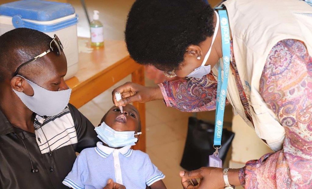 Un agent de santé administre un vaccin à un enfant au Burkina Faso