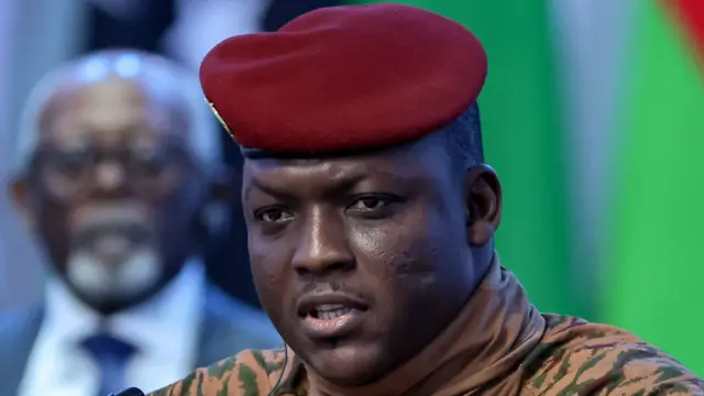 Portrait du capitaine Ibrahim Traoré en tenue militaire beige avec béret rouge.