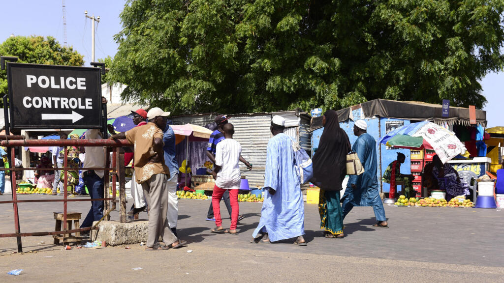 À Karang, au Sénégal, en mai 2016, des voyageurs franchissent le poste de contrôle policier pour rejoindre la Gambie.